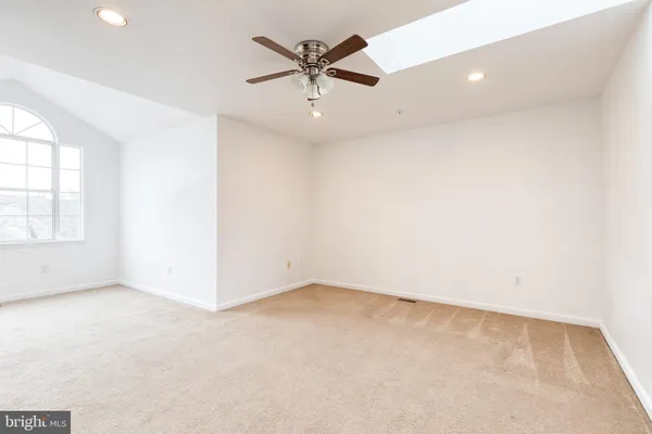 an empty room with a ceiling fan and window