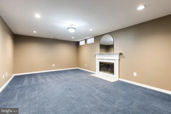 a view of an empty room with a fireplace and window