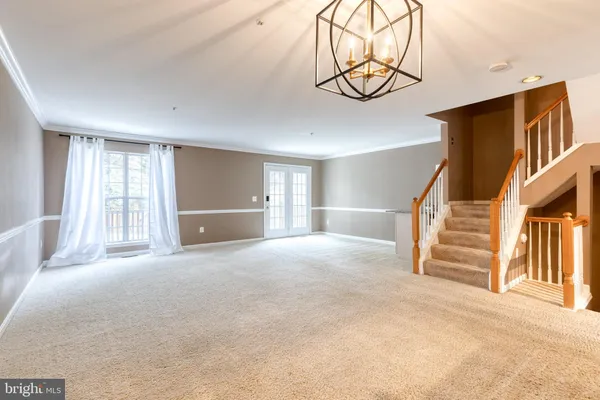 a view of an empty room with wooden floor and windows
