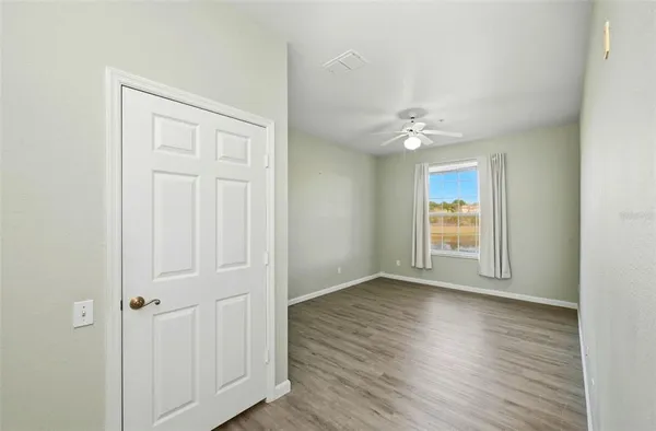 an empty room with wooden floor and window