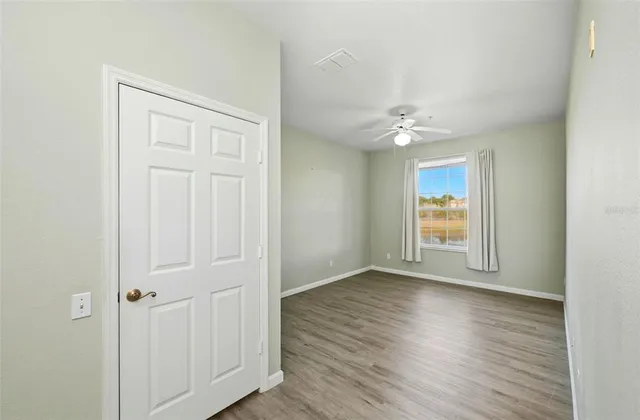 an empty room with wooden floor and window