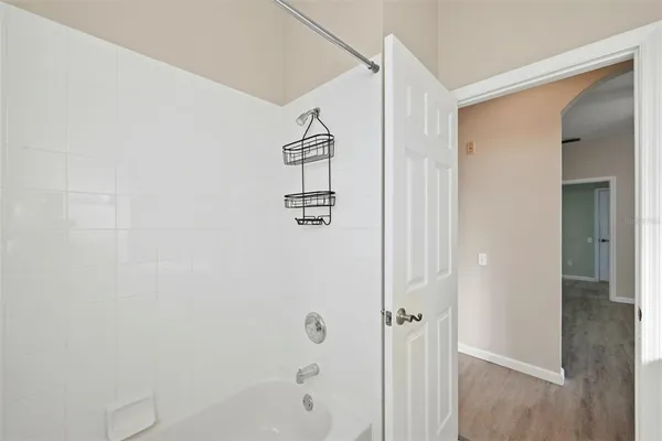 an empty room with a window and ceiling fan