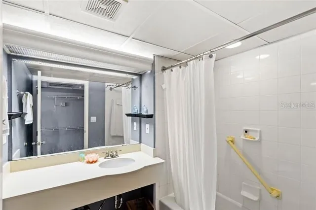 a bathroom with a sink mirror and a shower