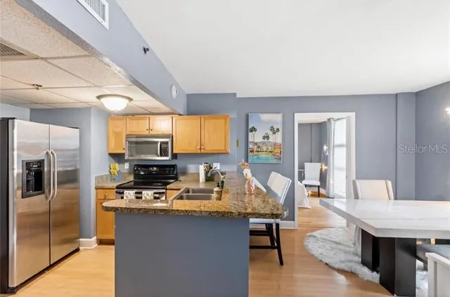 a kitchen with stainless steel appliances granite countertop a stove refrigerator and a sink