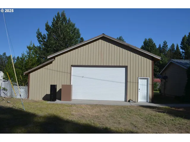 a view of backyard of house and garage