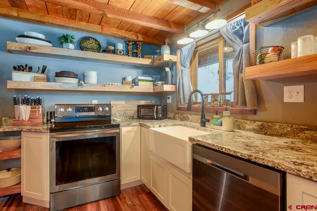 a kitchen with stainless steel appliances granite countertop a sink and a stove