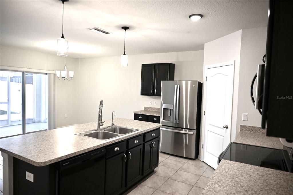 1036 Bethpage Road Auburndale, FL 33823 - Photo 6 of 18 a kitchen with stainless steel appliances kitchen island granite countertop a refrigerator a sink and dishwasher