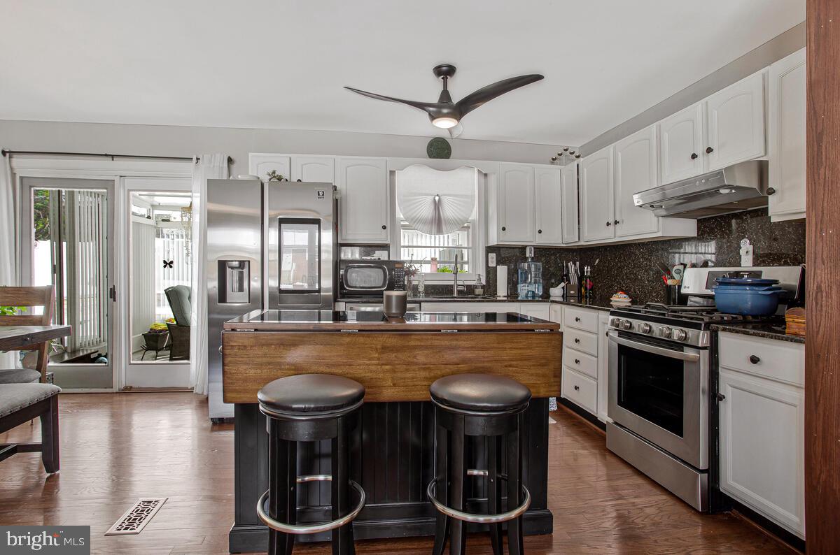 6617 Northgate Parkway Clinton, MD 20735 - Photo 12 of 36 a kitchen with stainless steel appliances granite countertop a stove a refrigerator a sink a stove and white cabinets with wooden floor