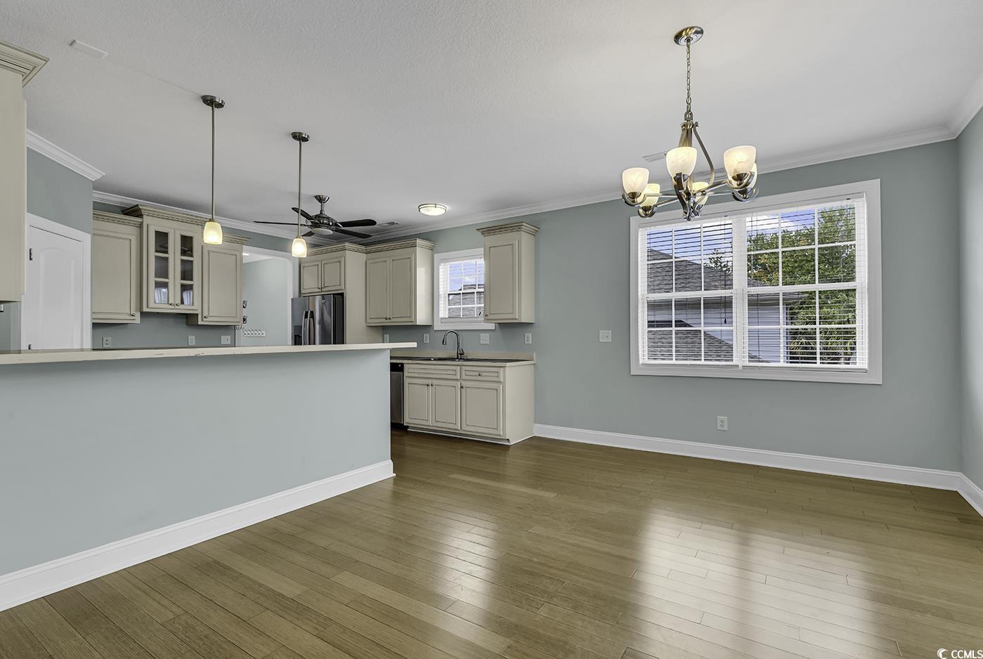 6 Cottage Drive Murrells Inlet, SC 29576 - Photo 12 of 31 Unfurnished dining area with crown molding, an inviting chandelier, and wood-type flooring
