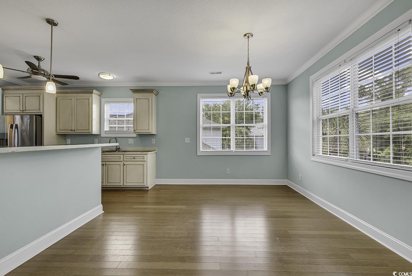 6 Cottage Drive Murrells Inlet, SC 29576 - Photo 13 of 31 Kitchen featuring crown molding, pendant lighting, hardwood / wood-style flooring, and stainless steel fridge with ice dispenser