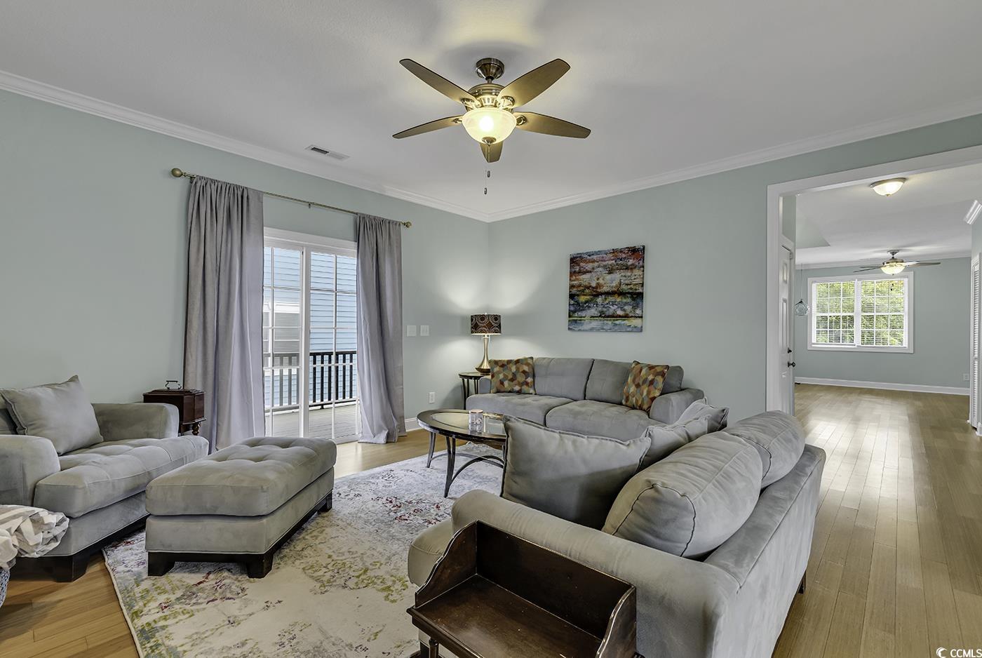 6 Cottage Drive Murrells Inlet, SC 29576 - Photo 14 of 31 Kitchen with cream cabinetry, ornamental molding, ceiling fan with notable chandelier, wood-type flooring, and stainless steel fridge with ice dispenser
