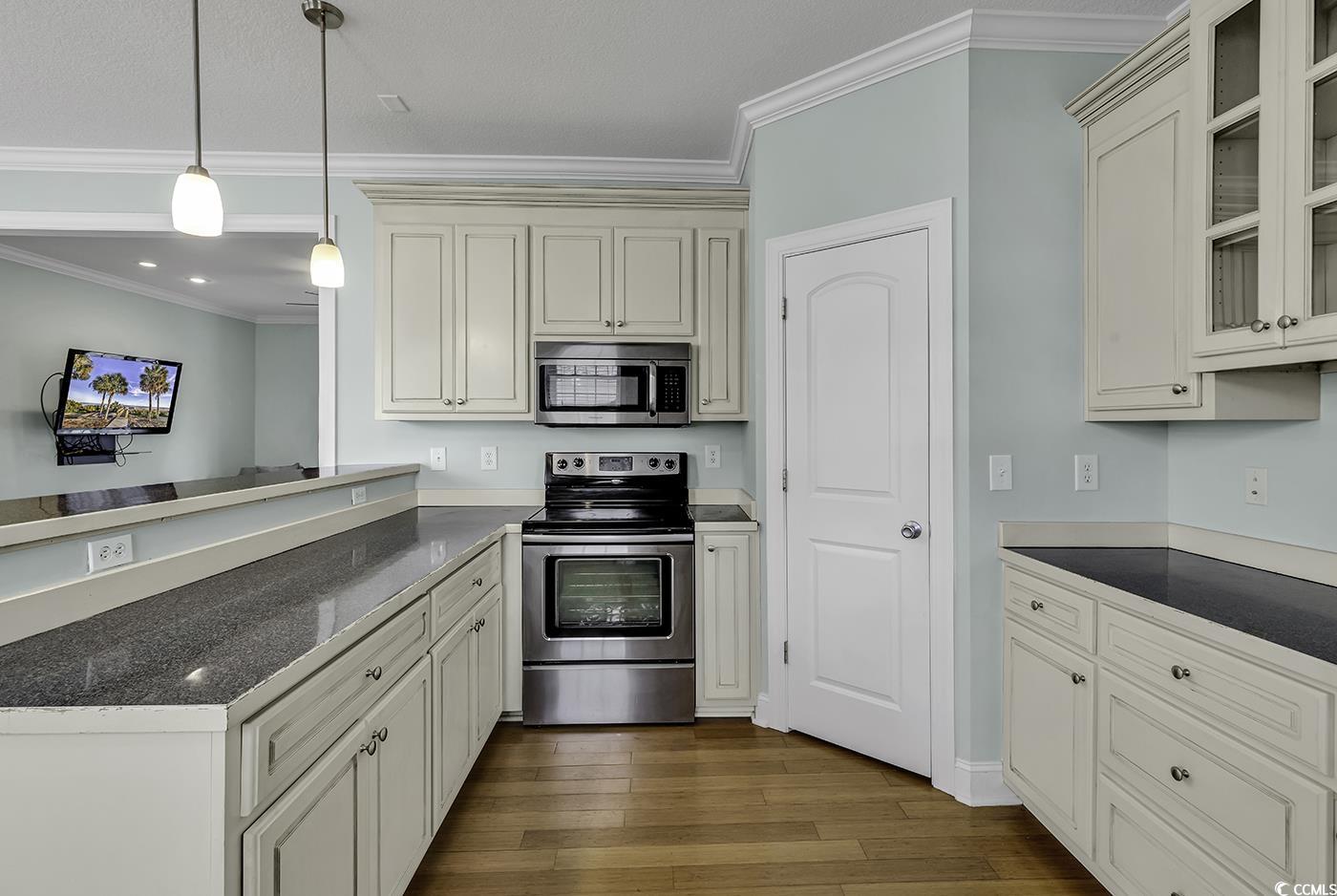 6 Cottage Drive Murrells Inlet, SC 29576 - Photo 9 of 31 Kitchen featuring ornamental molding, light hardwood / wood-style flooring, stainless steel appliances, and cream cabinetry