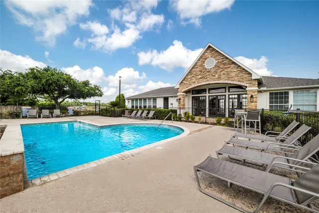 a view of a house with swimming pool and sitting area