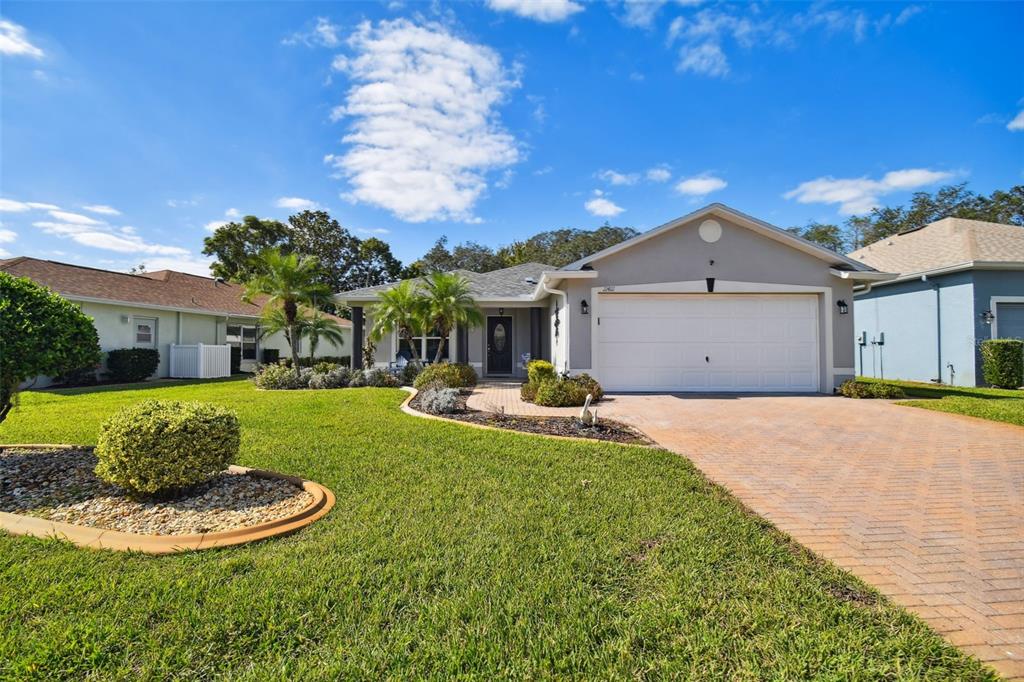11411 Turtle Dove Place New Port Richey, FL 34654 - Photo 1 of 1 a front view of a house with a yard garage and outdoor seating