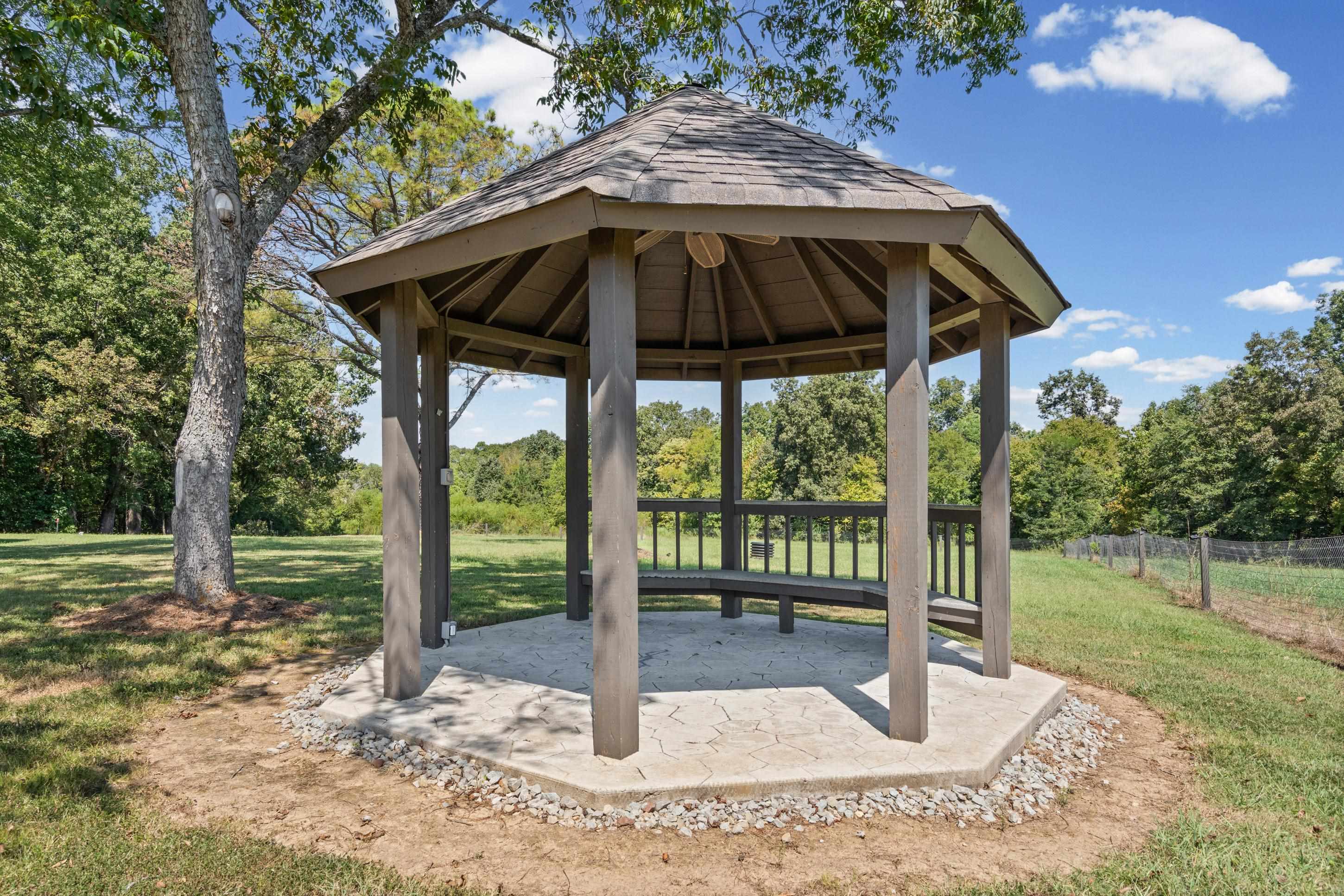 620 Diffee Road Moscow, TN 38057 - Photo 21 of 25 Gazebo featuring a shingled roof, built-in wooden seating, and a concrete base