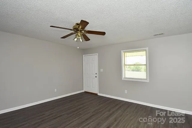 a view of room with wooden floor and windows