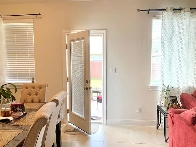a dining room with furniture a chandelier and a window