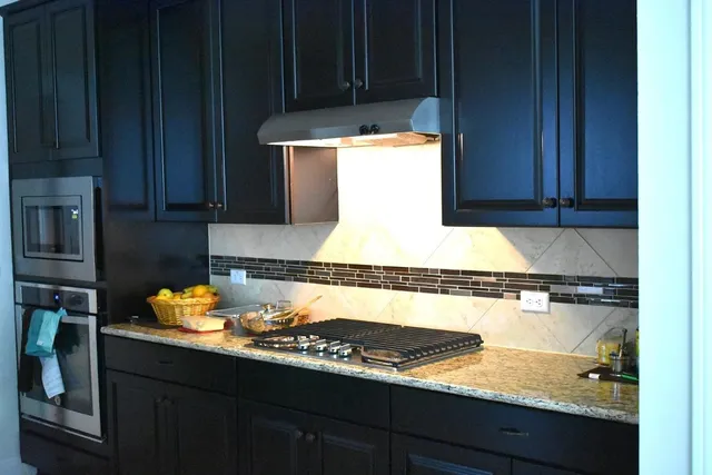 a kitchen with stainless steel appliances granite countertop a stove and a refrigerator