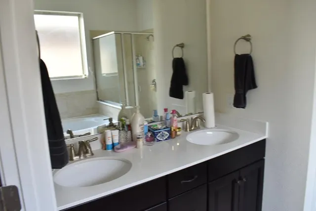 a bathroom with double vanity sink and a mirror
