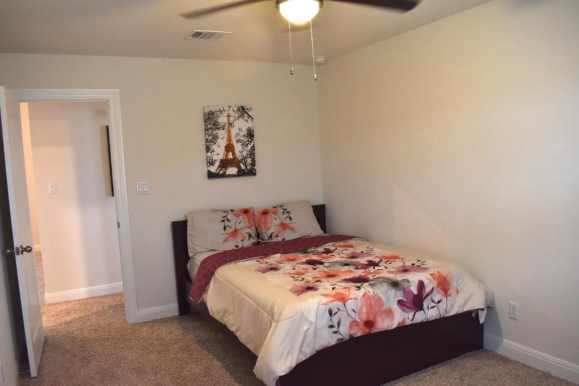 1109 Sundrops Street Leander, TX 78641 - Photo 29 of 40 a bedroom with a bed and a chandelier
