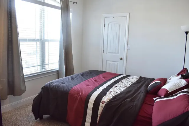 a bed sitting in a bedroom next to a window