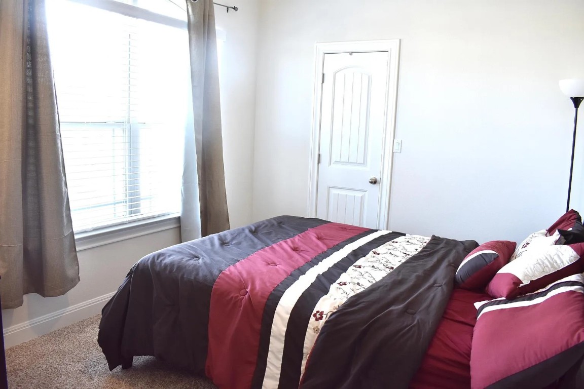 1109 Sundrops Street Leander, TX 78641 - Photo 36 of 40 a bed sitting in a bedroom next to a window