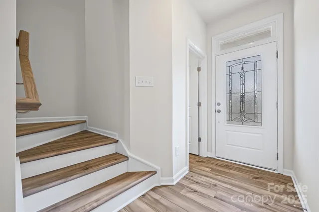a view of a hallway with wooden floor and entryway
