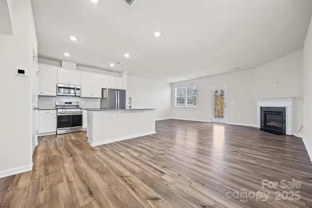 a view of kitchen with wooden floor and electronic appliances