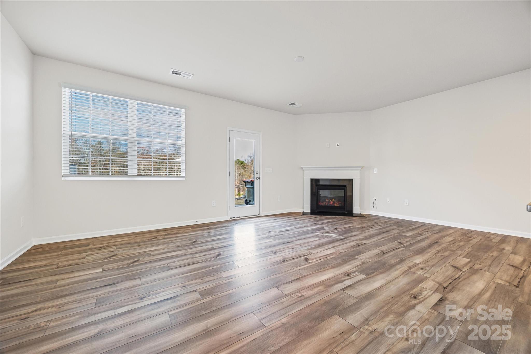 5038 Moss Pne Way Fort Mill, SC 29708 - Photo 7 of 25 a view of empty room with wooden floor and fireplace