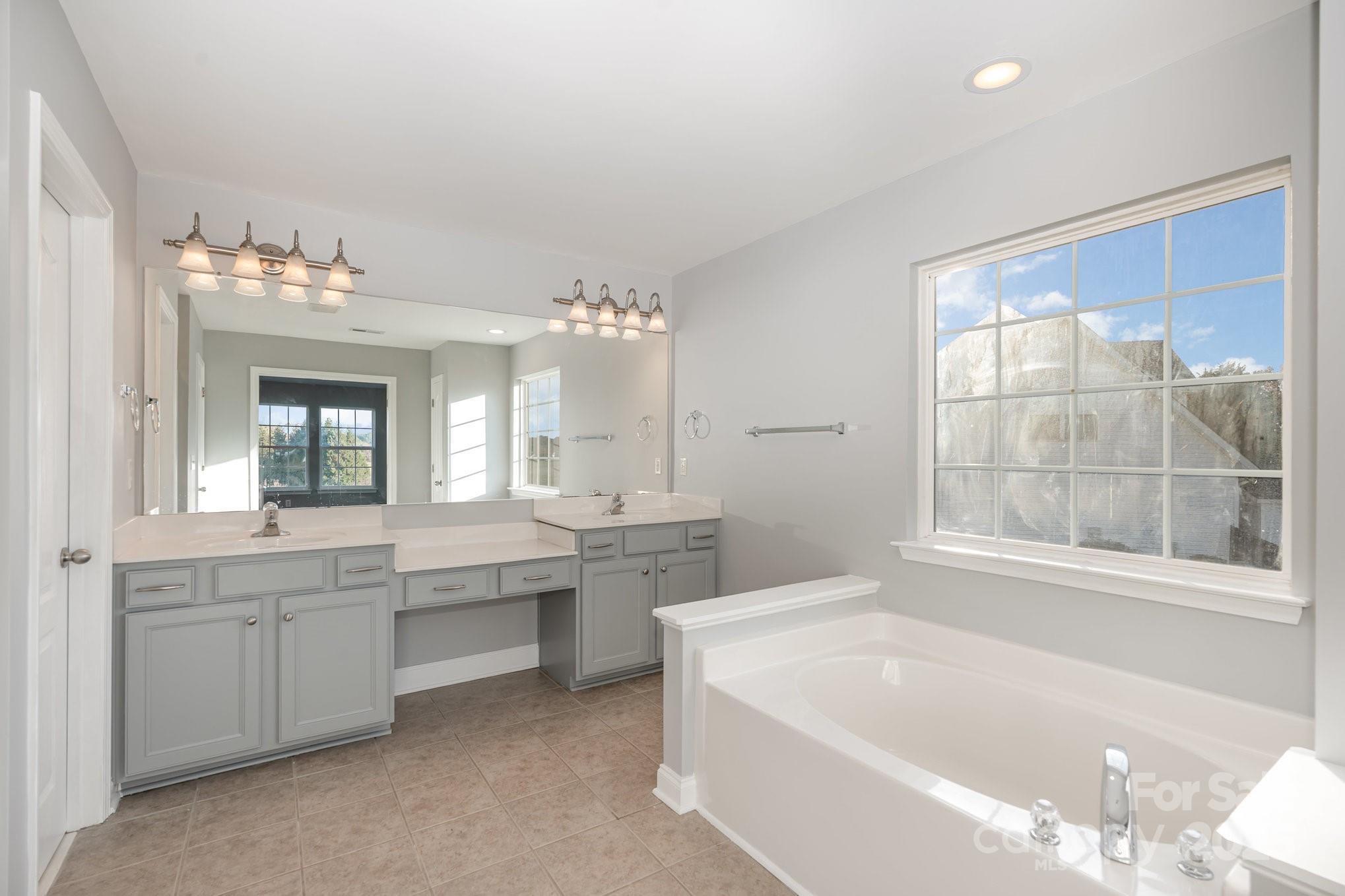 1457 Jc Raulston Court Hickory, NC 28602 - Photo 32 of 39 a bathroom with a tub sink and mirror