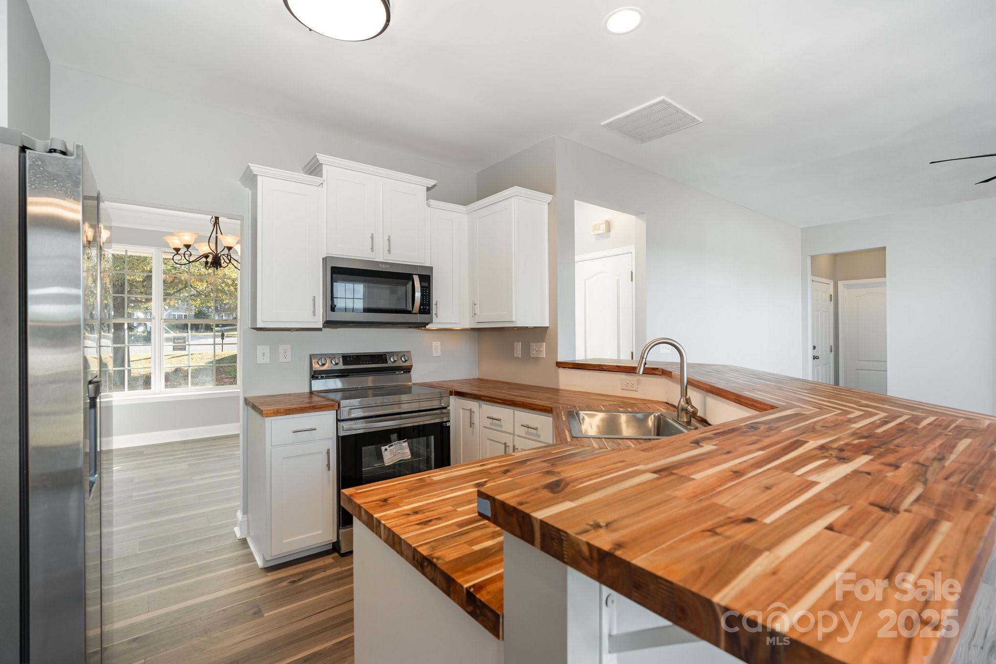 1457 Jc Raulston Court Hickory, NC 28602 - Photo 9 of 39 a kitchen with stainless steel appliances granite countertop a stove a sink and a microwave