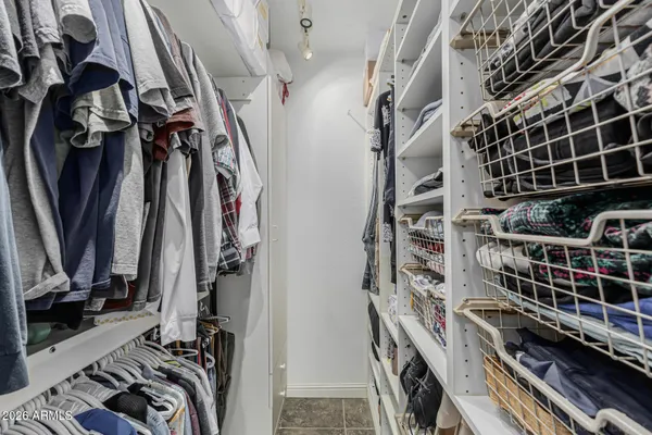 a view of walk in closet with clothes and shoes