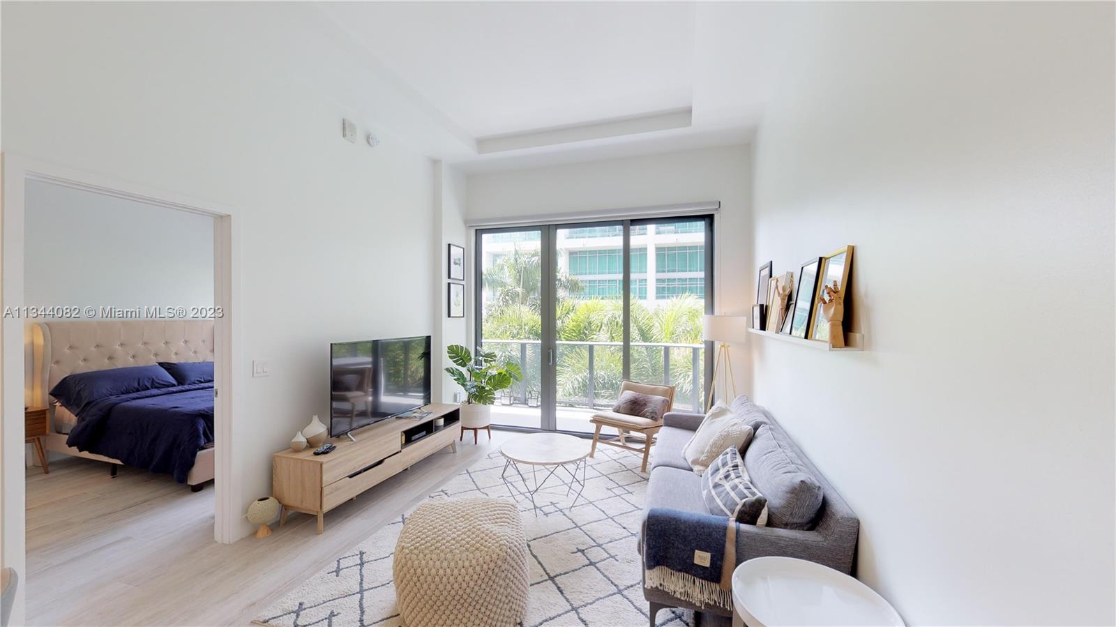 121 Northeast 34th Street, Unit L202 Miami, FL 33137 - Photo 1 of 40 a living room with furniture and a large window