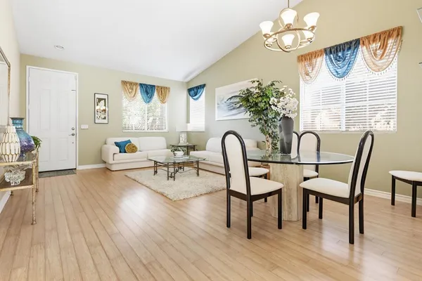 a view of a dining room with furniture wooden floor and a chandelier