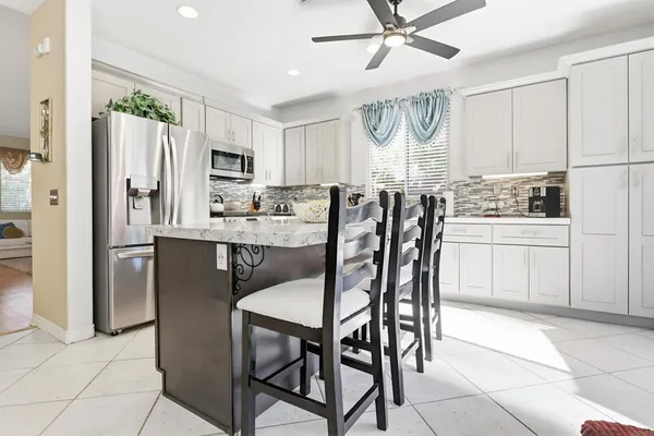 a kitchen with stainless steel appliances a table chairs and chandelier