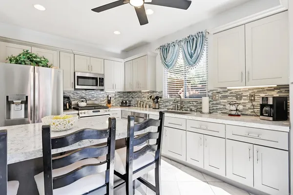 a kitchen with white cabinets and appliances