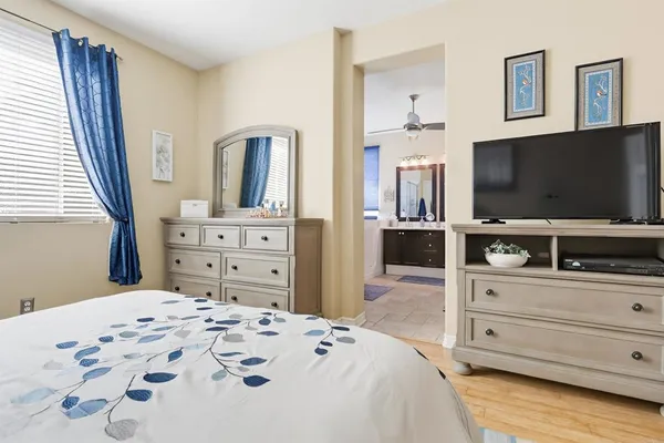 a bedroom with a bed and a flat screen tv in white dresser