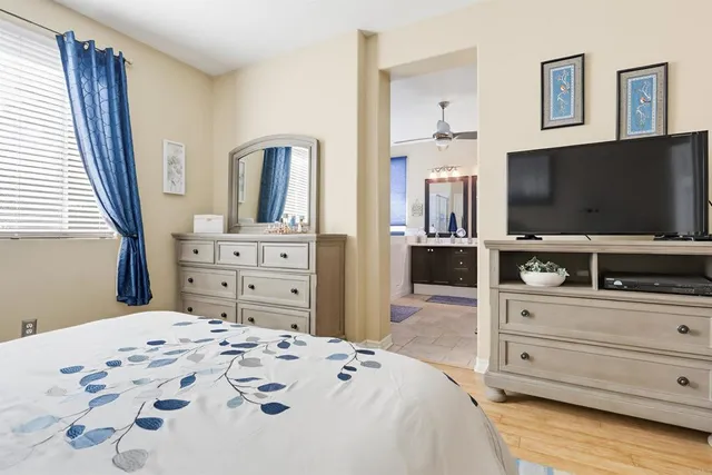 a bedroom with a bed and a flat screen tv in white dresser