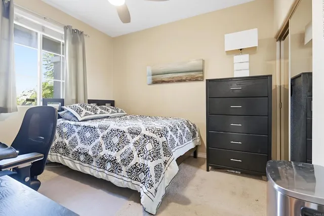 a bedroom with a bed and large windows