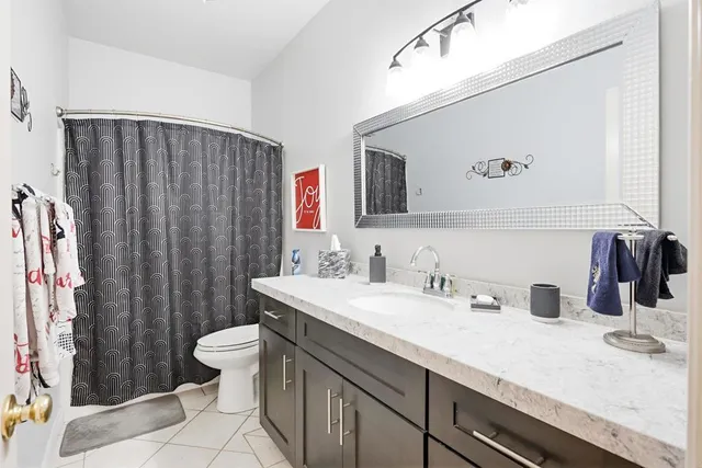a bathroom with a double vanity sink toilet and shower