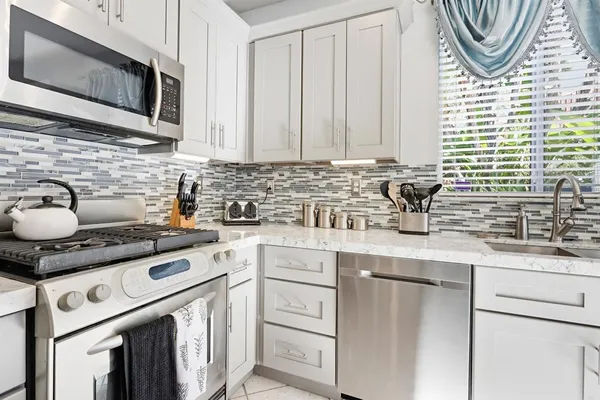 a kitchen with stainless steel appliances a stove a sink and a microwave