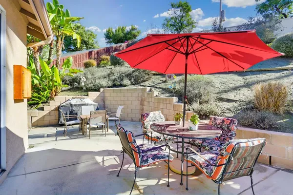 a view of a patio with table and chairs under an umbrella