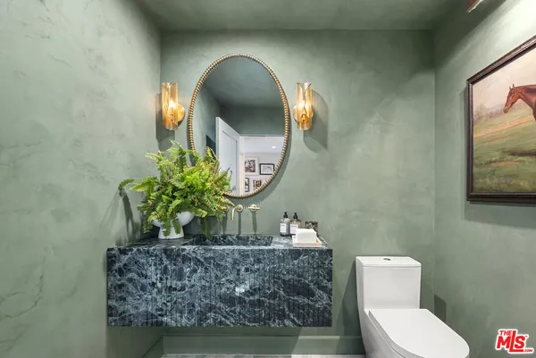 a bathroom with a toilet and a mirror
