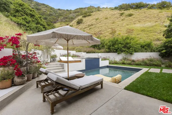 a patio with a table and chairs under an umbrella