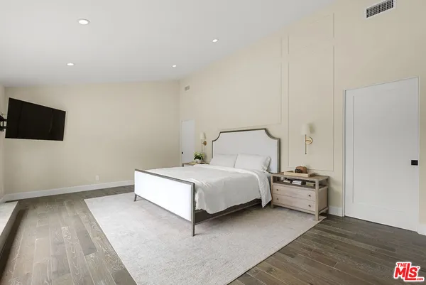 a bedroom with a bed and a flat screen tv