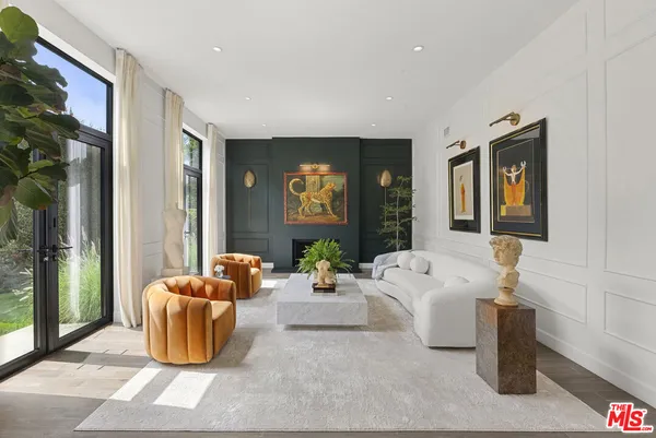a living room with furniture a window and a potted plant