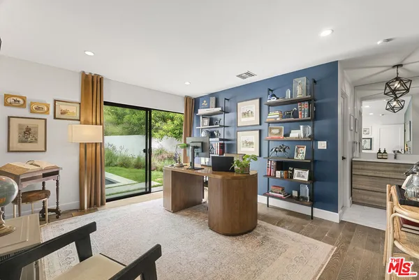 a living room with furniture a bookshelf and a large window