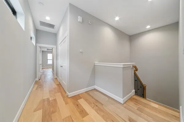 a view of a hallway with wooden floor