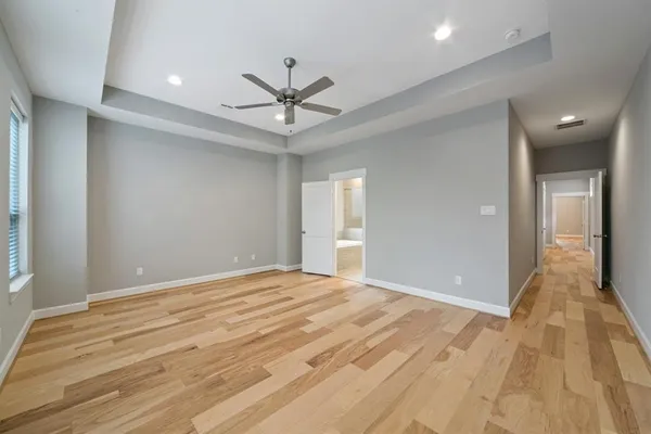 a view of a big room with wooden floor and windows in a room