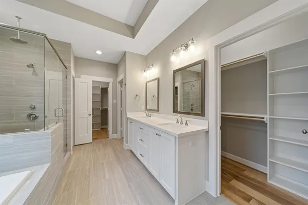 a bathroom with a double vanity sink mirror and shower